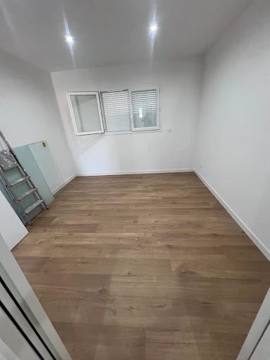 Chambre terminée, murs peints en blanc et parquet posé
